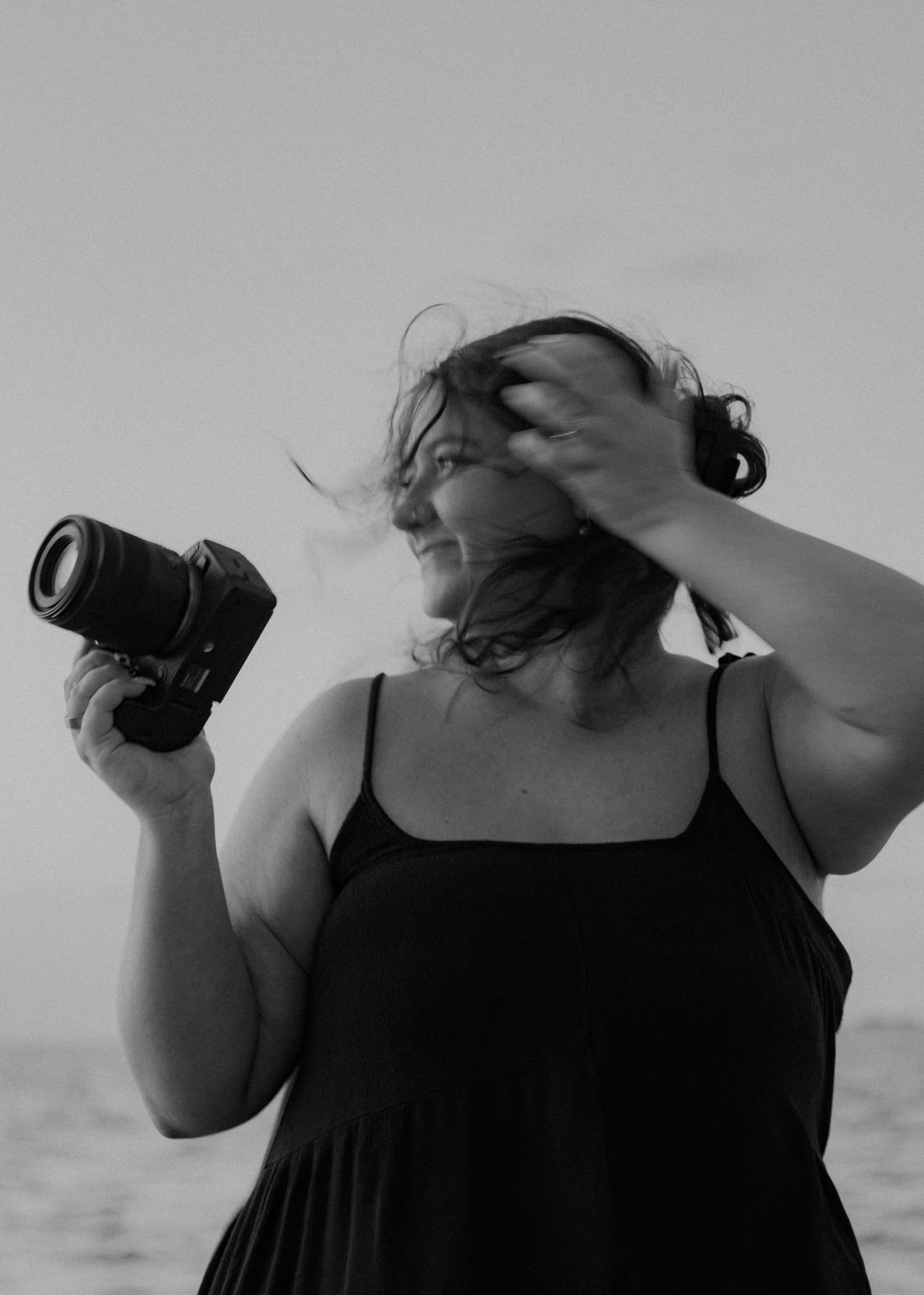 Black-and-white portrait of Madison holding her camera