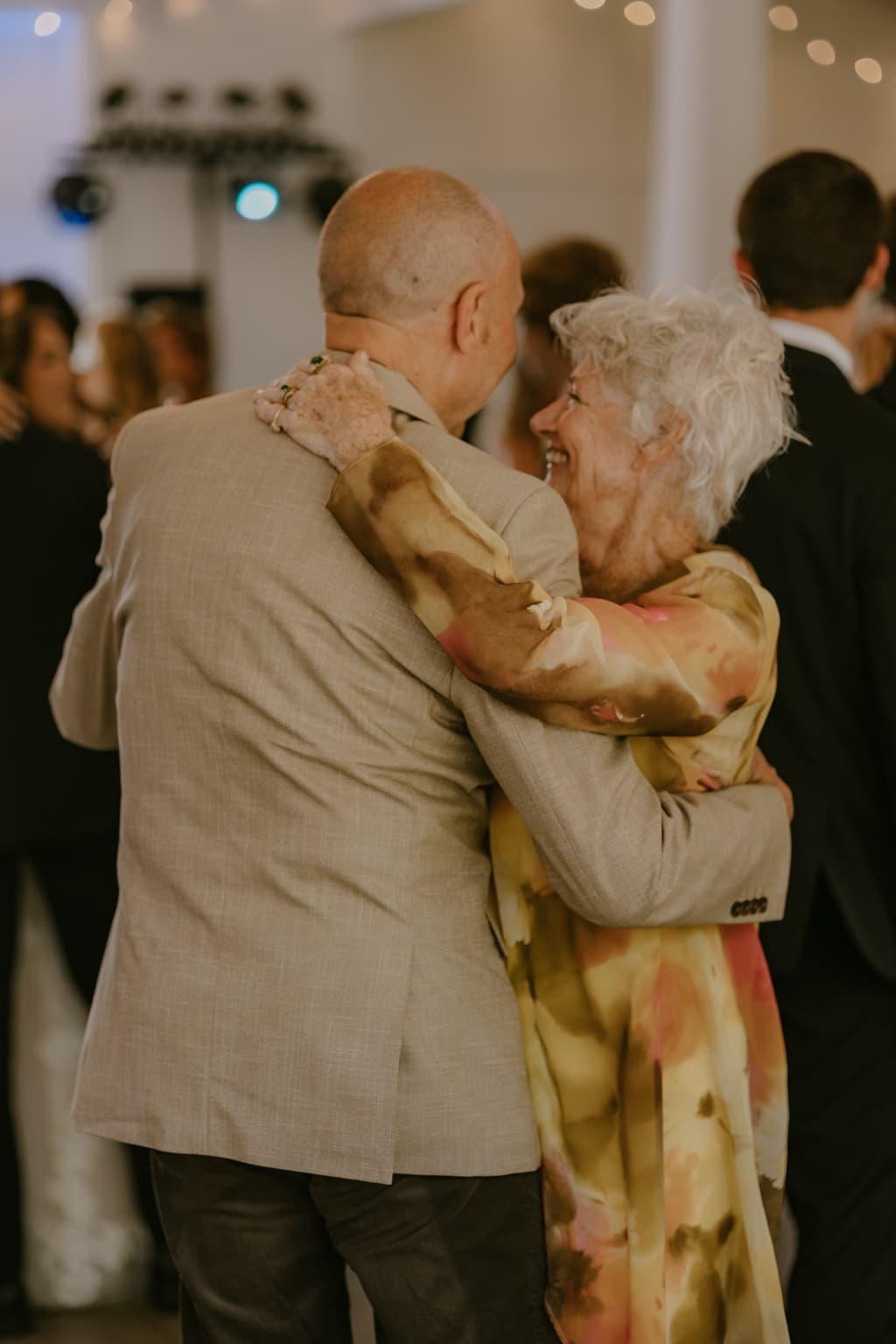 Older couple smiling while dancing together at the wedding reception