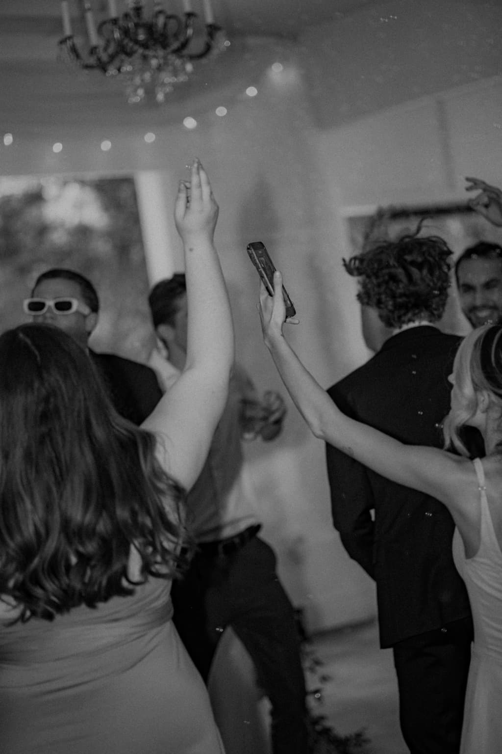 Black-and-white candid photo of guests dancing during the wedding reception
