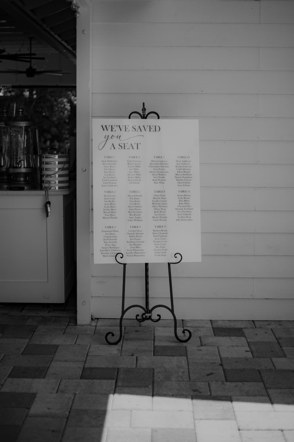 Black-and-white wedding seating chart displayed on an easel